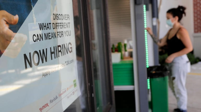 A "Now Hiring" sign is displayed during the pandemic in...