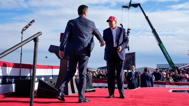 Republican presidential candidate former President Donald Trump, right, shakes hands...