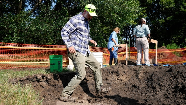 Nebraska State Archeologist Dave Williams walks in a hole as...
