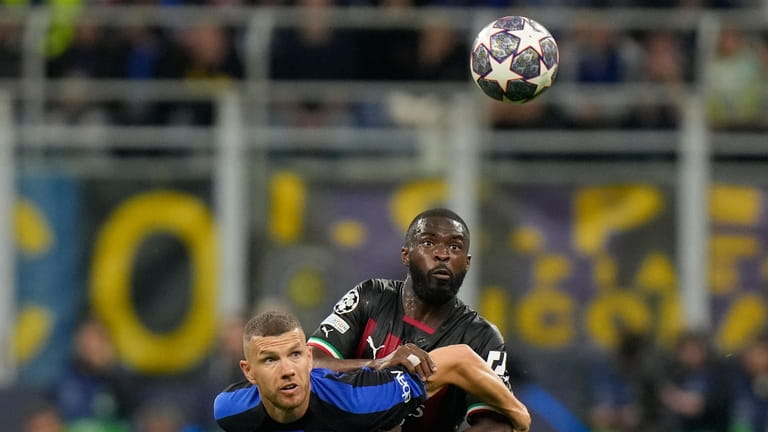 AC Milan's Fikayo Tomori, right, fights for the ball with...