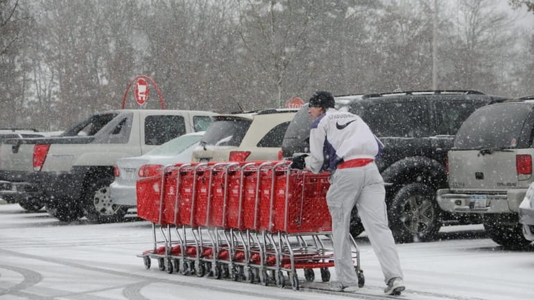 A worker at Target in Medford fights through heavy snow...
