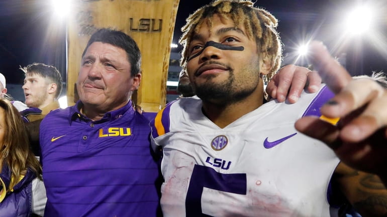 LSU head coach Ed Orgeron, left, celebrates with running back...