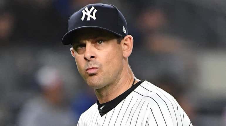 New York Yankees manager Aaron Boone walks to the dugout...