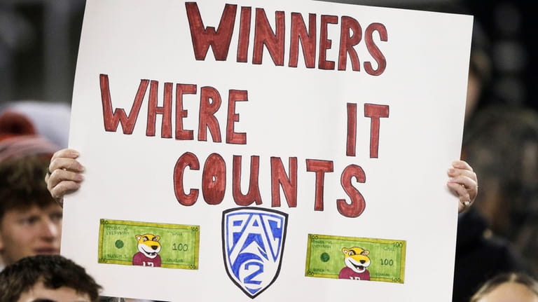 A Washington State fan holds a "Pac-2" sign before an...