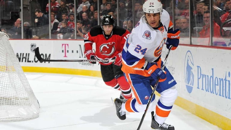 Steve Staios of the New York Islanders controls the puck...