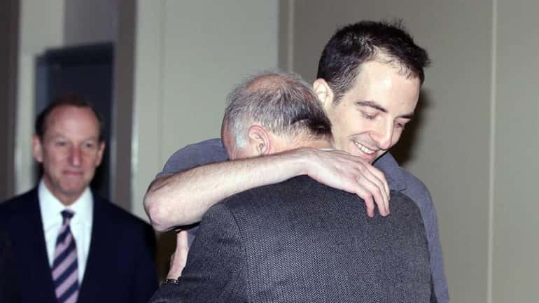 Ilan Grapel hugs his father Daniel inside a JFK Airport...