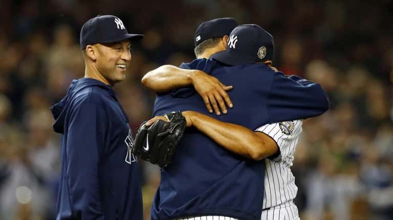 Mariano Rivera #42 of the Yankees hugs teammate Andy Pettitte #46...