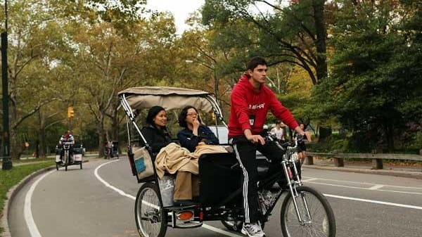 Tourists ride in a New York City pedicab through Central...
