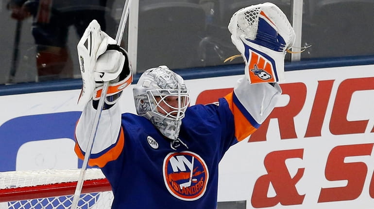 Robin Lehner #40 of the Islanders celebrates after defeating the...