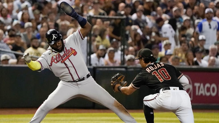 Atlanta Braves' Marcell Ozuna leans out of the way from...