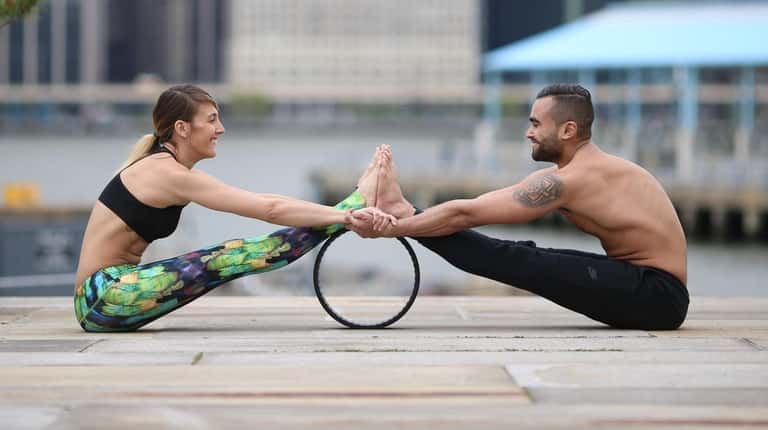 Dov Vargas and Raquel Vamos use a dharma yoga wheel that...