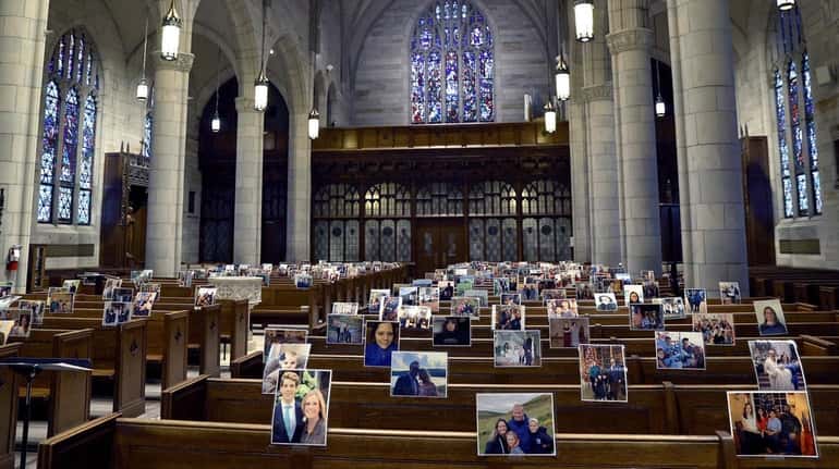 Parishioners' photos are seen in the pews as a priest...