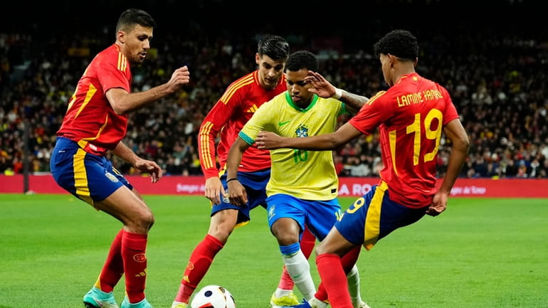 Brazil's Rodrygo, centre right, tries to get past Spain's Rodrigo,...