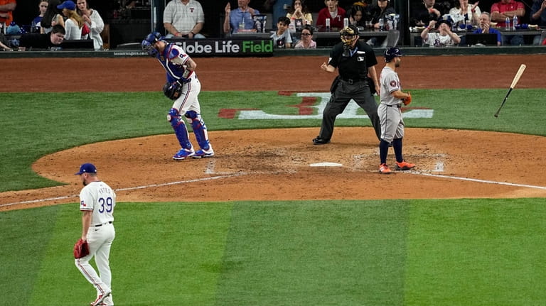 Houston Astros' Jose Altuve, right, tosses his bat after striking...