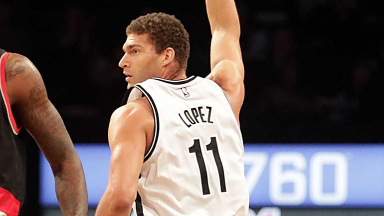 Brooklyn Nets center Brook Lopez (11) signals a three-pointer as...