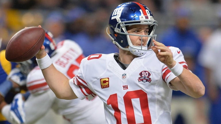 Eli Manning #10 of the New York Giants passes against...