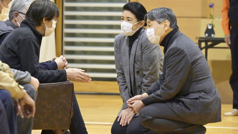 Japanese Emperor Naruhito, right, and Empress Masako visit the victims...