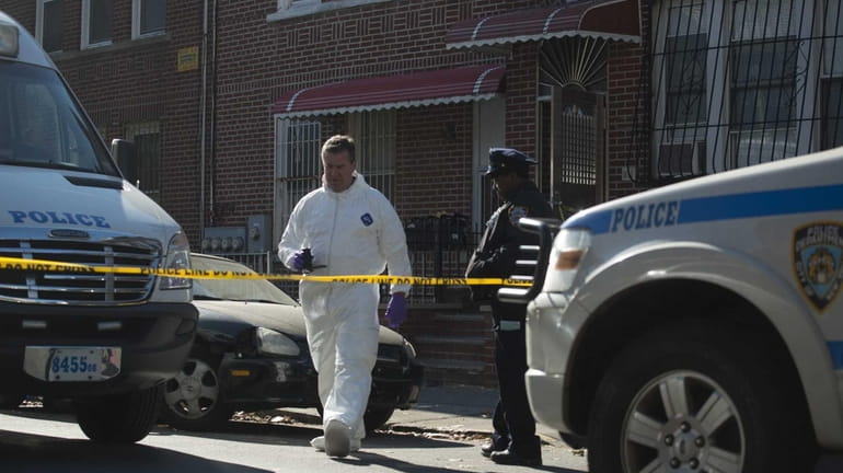 NYPD crime scene unit members gather evidence in a mass...