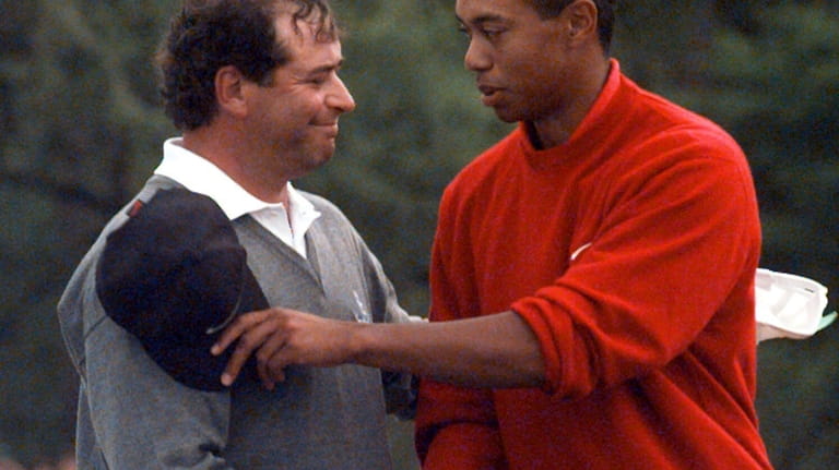 Masters champion Tiger Woods is congratulated by his playing partner...