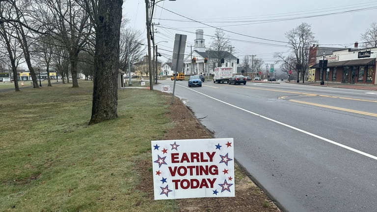 Signs dot the town green in Colchester, Conn., on Wednesday,...