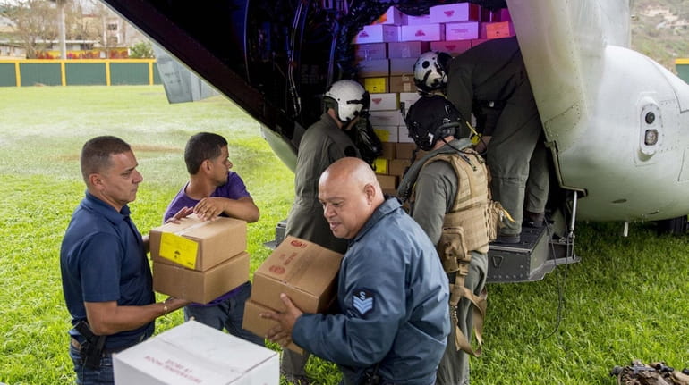 Marines unload food from a military aircraft in Jayuya, Puerto...