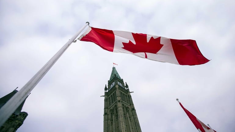 A Canadian flag flies in front of the peace tower...