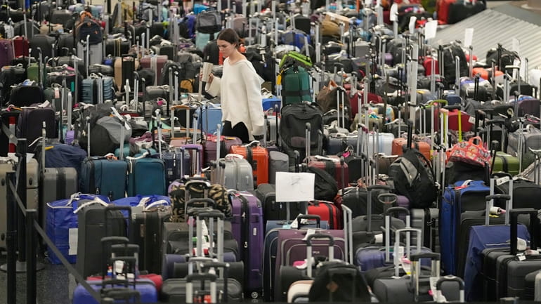 A woman walks through unclaimed bags at Southwest Airlines baggage...