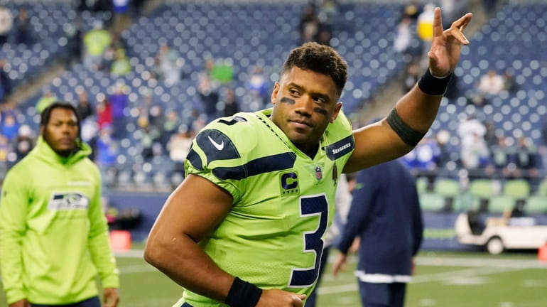 Russell Wilson waves to fans as he leaves the field...