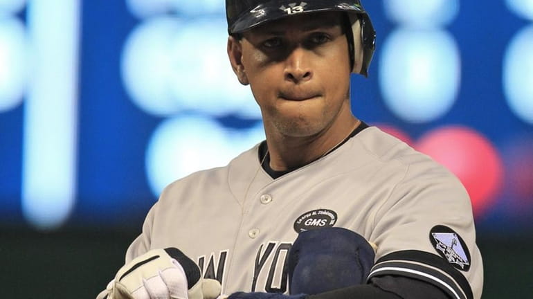New York Yankees' Alex Rodriguez takes off his batting gloves...