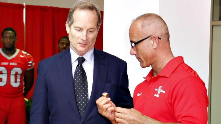 Alumnus/benefactor Glenn Dubin receives a championship ring from head football...