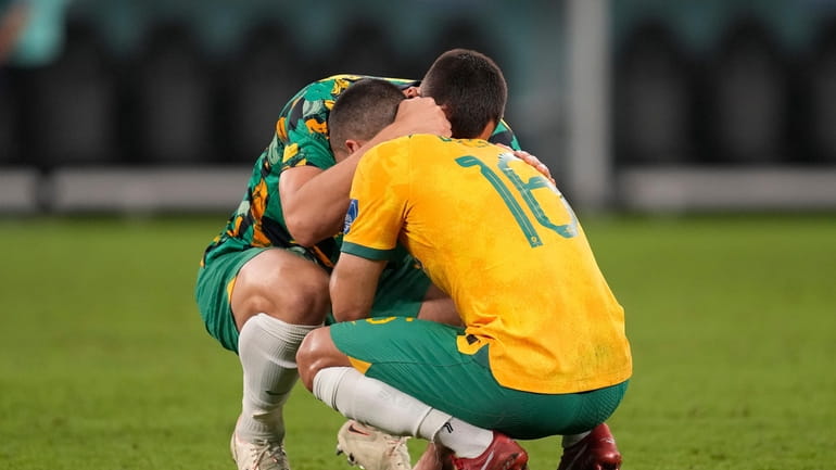 Australia's Aziz Behich is comforted after losing the World Cup...