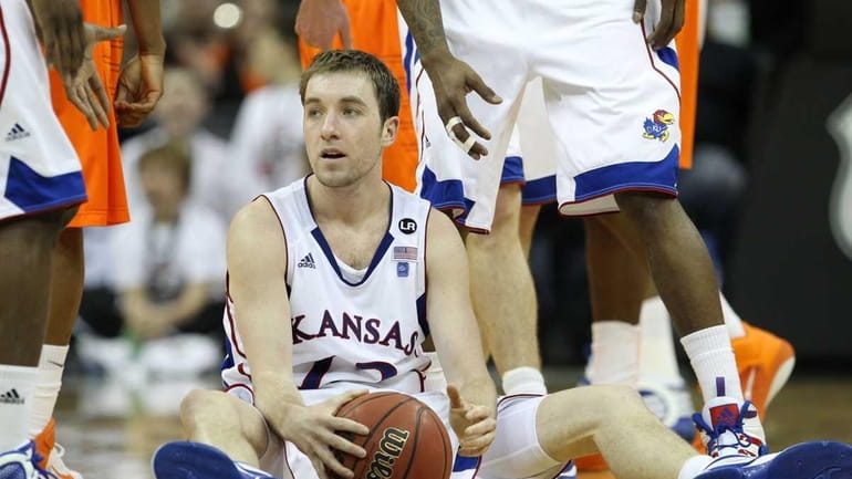 Kansas' Brady Morningstar sits on the court after being called...