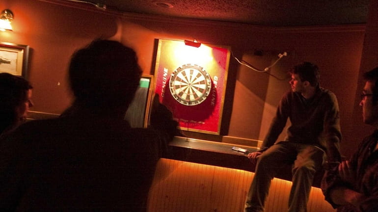 Group of patrons play a round of darts at Katie's...