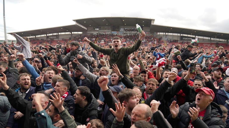 Wrexham fans invade the pitch celebrating promotion to League One...