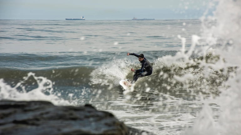 A surfer takes to the waters off Long Beach on...