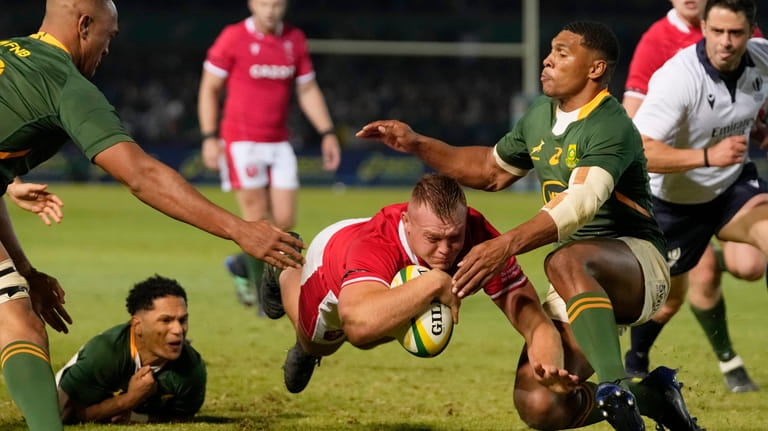 Wales' Dewi Lake, center, scores a try during the Rugby...