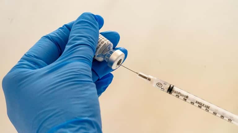 Registered pharmacist Paula Agoglia fills a dead-volume syringe with the...