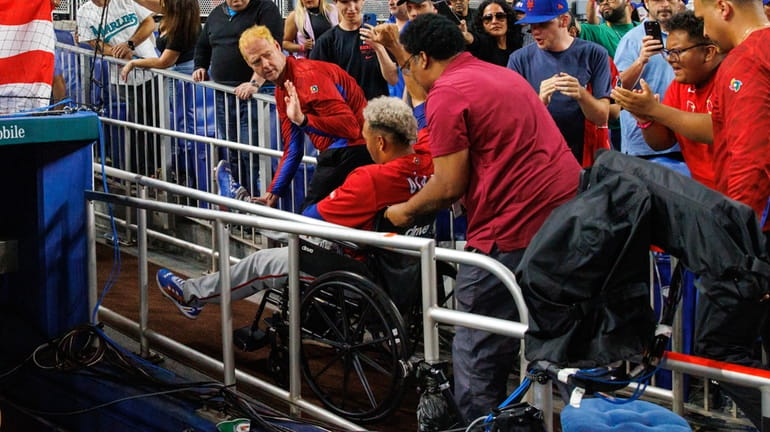 Puerto Rico pitcher Edwin Diaz leaves in a wheelchair after...