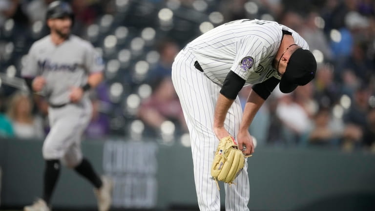 Colorado Rockies starting pitcher Austin Gomber reacts after giving up...