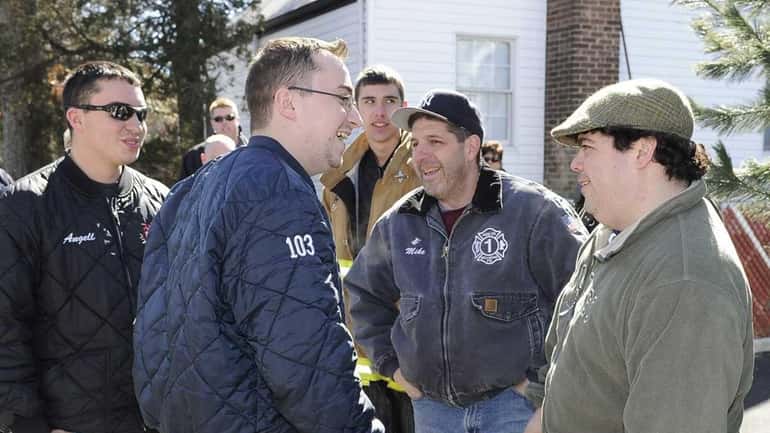 Wounded Bellmore firefighter Justin Angell, left, is greeted by firefighters...