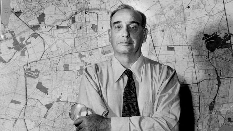 Robert Moses in front of a map of Long Island...