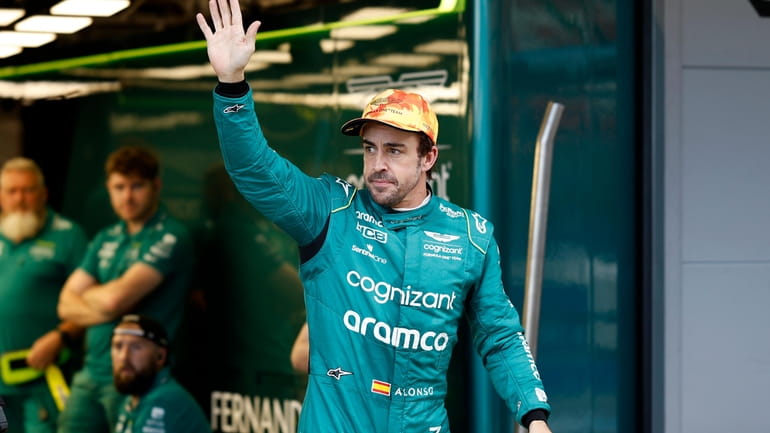 Aston Martin driver Fernando Alonso of Spain gestures to fans...