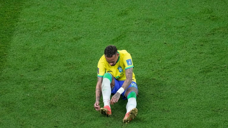 Brazil's Neymar, lies on the pitch during the World Cup...