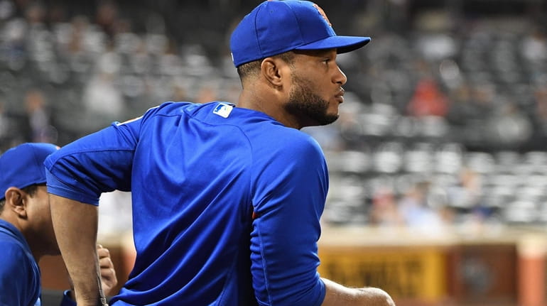 New York Mets' Robinson Cano looks on from the dugout...