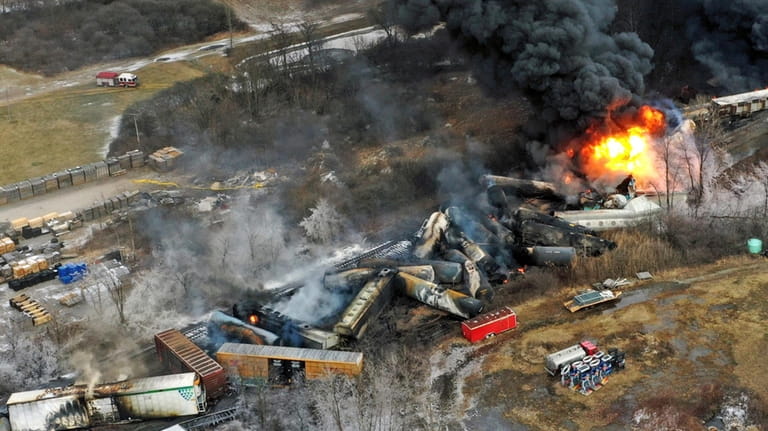 Debris from a Norfolk Southern freight train lies scattered and...