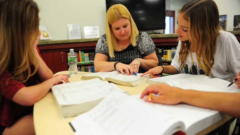 SAT tutor Amy Fortsch, center, coaching students Laura Isaacson, left,...