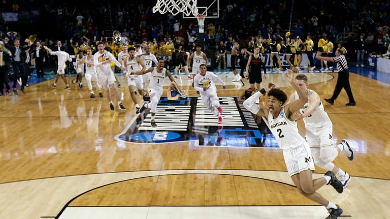 Michigan guard Jordan Poole (2) is chased by teammates after...