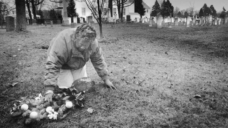 Eleanor Lingo places a wreath on the grave of "Bloom,"...