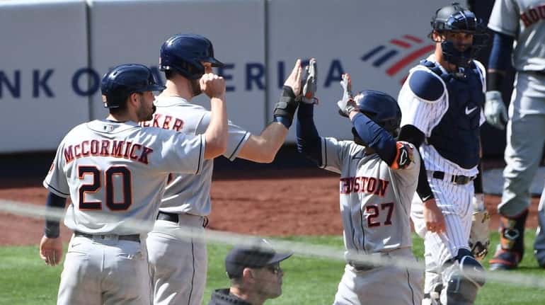 The Astros' Jose Altuve and teammates celebrate his three-run home...