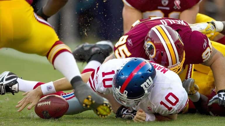 The balls comes lose from New York Giants quarterback Eli...